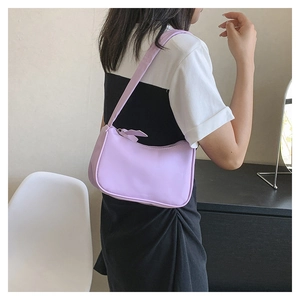 Detailed view of a light purple crescent underarm bag worn by a model on shoulder