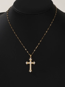 Detailed view of a gold cross necklace with clear zircons on a black neck bust