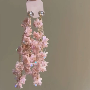 Detail of pink resin flower tassel earrings with gold chain and clear crystal studs