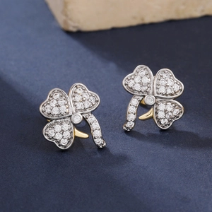 Micro shot of clover-shaped stud earrings with micro-set zircons on dark blue background