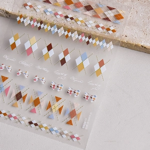 Macro shot of colorful argyle and bow nail art stickers with elegant text details