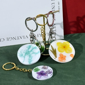 Vue détaillée de porte-clés ronds en résine avec de vraies fleurs séchées et métal