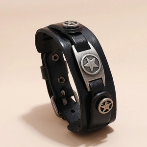 Dettaglio del bracciale in pelle nera con borchie a stella e fibbia in metallo regolabile
