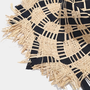 Detail view of bicolor raffia sun hat featuring woven check pattern and frayed fringe edges