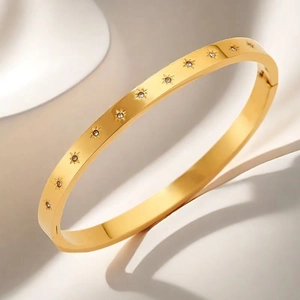Close-up of gold stainless steel starburst bracelet with clear zircon inlay details