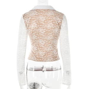 Détail du haut en dentelle florale blanche avec manches cloches et col polo au dos