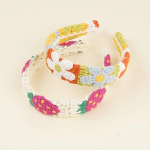 Detailed macro view of handmade crochet headbands with daisy and strawberry patterns