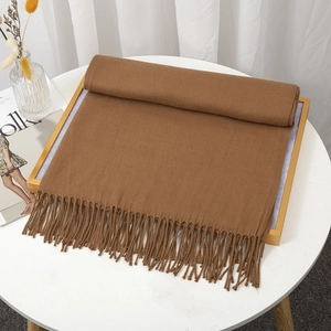 Deep brown cashmere-like scarf with hand-twisted tassels on a minimalist table set