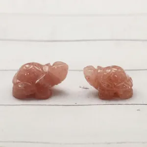 Pair of carved rose quartz turtle figurines on a wooden surface with a warm aesthetic