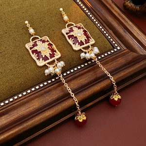 Detail of vintage flower earrings with pearls and red beads on green velvet background
