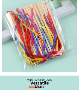 Detail of wooden DIY scratch paper tools tied with colorful ribbons in clear packaging