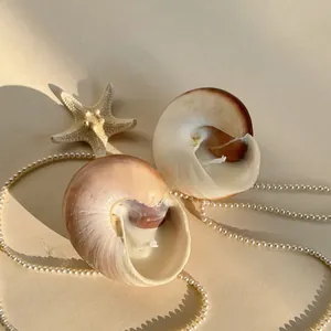 Detailed view of ocean-inspired shell candles with white wax and natural starfish decor
