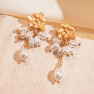 Boucles d'oreilles fleur dorée avec pampilles de perles blanches sur plaque céramique