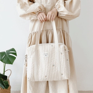 Quilted cotton diaper bag with floral embroidery and dual shoulder straps