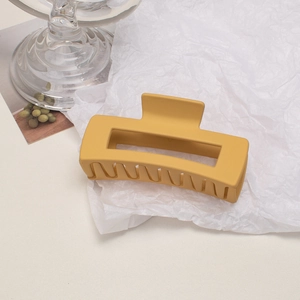 Macro shot of large matte cream yellow hair claw clip with rectangle hollow design