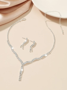 Detailed view of silver bridal jewelry set with sparkling rhinestones on silk fabric