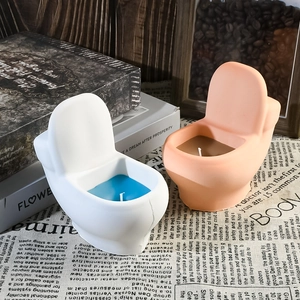 Detail of creative toilet-shaped scented candles in white and pink on a retro table