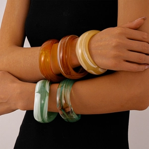 Retro geometric wide acrylic bangles with marble texture shown on a model arm