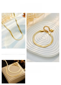 Detailed views of gold snake chain set with lobster clasp and heart charm details