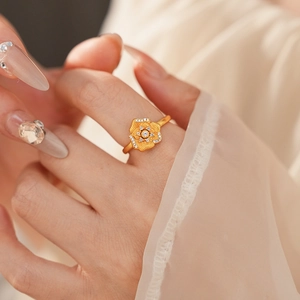 Close-up of a vintage golden flower ring with white zircon stones on model's hand
