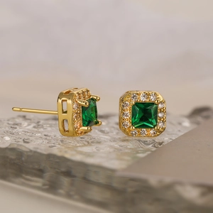 Macro detail of square emerald-cut green gemstone earrings with pavé zircon halo