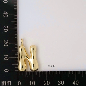 Detail view of gold letter N balloon pendant with mm ruler and 5.4g weight mark