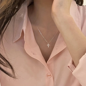 Macro detail of a 925 sterling silver cross necklace with pavé-set cubic zirconia stones
