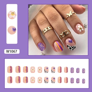 Short square press-on nails with colorful wavy lines, daisies, and cow print patterns