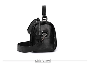 Seitenansicht der schwarzen Boston-Tasche mit Ledertextur und abnehmbarem Gurt