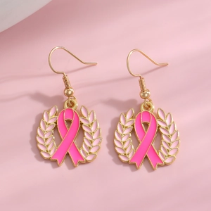 Details von vergoldeten Brustkrebs-Ohrringen mit rosa Schleife und Emaille-Blättern