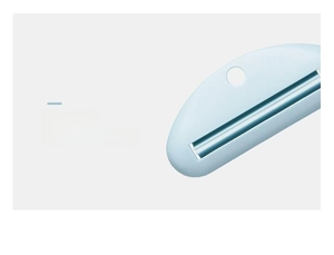 Detail of light blue manual toothpaste squeezer with narrow slot and hanging hole