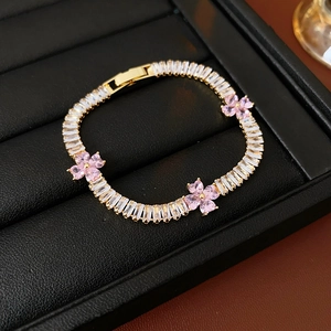 Detail of luxury gold bracelet with pink zircon flowers in a black leather gift box