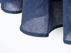 Dettaglio dell'orlo dell'abito midi blu scuro con trama in lino traspirante e naturale