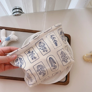 Detail of floral printed cotton pouch showing soft fabric texture and vintage blue pattern
