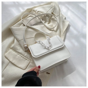 Top view of a white PU leather crossbody bag with a thick white chain on a white blazer