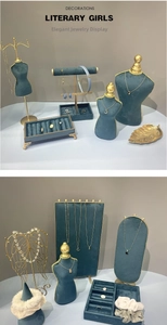 Detail of luxury green velvet jewelry display set with gold metal frames and stands