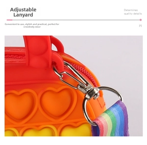 Detail view of heart-shaped silicone pop purse with adjustable rainbow strap and metal buckle