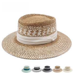 Detail of woven straw boater hat texture with pleated ribbon and color variations