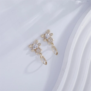 Detailed close-up of gold bear earrings with micro-pave cubic zirconia and drop center stone