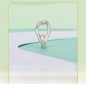 Macro shot of S925 sterling silver heart charm with engraved hallmark on a clean background