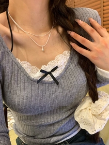 Double-layer stainless steel necklace featuring a silver teardrop pendant on a female model