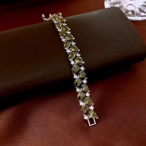 Détail de bracelet en argent serti de pierres vertes taille poire et oxydes