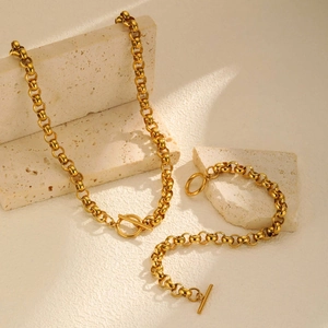 Detailed close-up of gold stainless steel necklace and bracelet set with toggle clasp