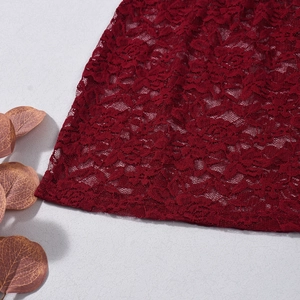 Gros plan détaillé du tissu en dentelle rouge vin avec motifs floraux complexes