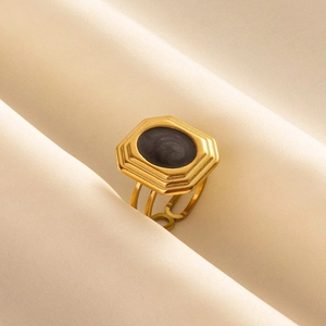 Detail of vintage 304 stainless steel ring with black oval inlay on textured fabric