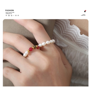 Close-up of handmade beaded ring with pearls and agate worn on finger for vintage style