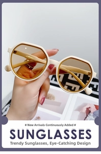 Detail of cream white geometric round sunglasses with light brown tinted lenses in hand