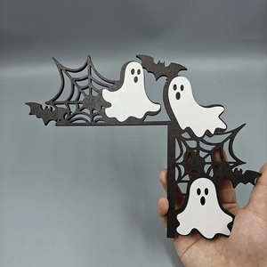 Close-up of wooden Halloween door corner decor featuring white ghosts and black spider web