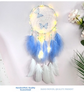 Detailed view of handmade dream catcher with butterfly accents and warm LED fairy lights