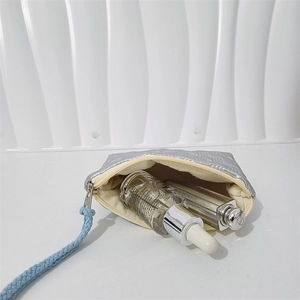 Silver quilted heart pouch with blue wrist strap and metallic zipper closure